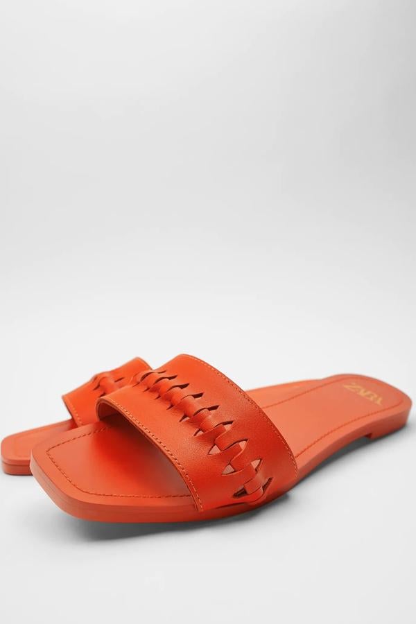 En color naranja (también disponible en blanco), estas sandalias planas de piel con detalle trenzado en la parte superior son de Zara y tienen un precio de 25,95 euros.