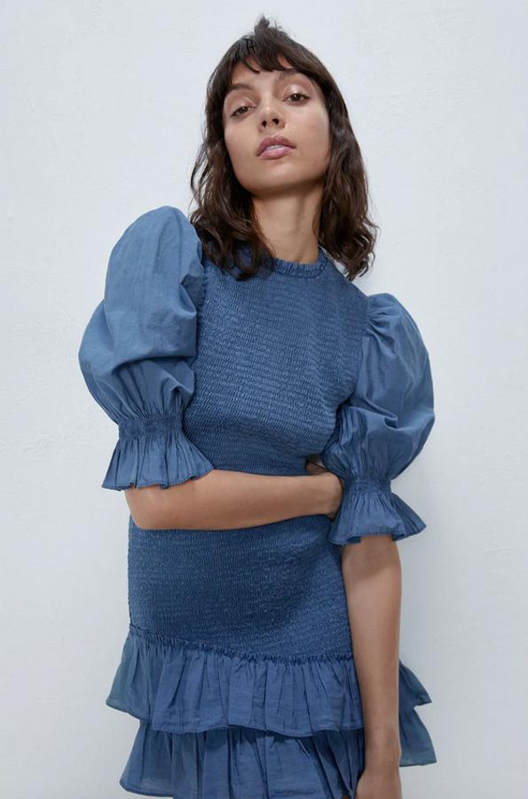 Con mangas y bajo acabadas en volante, este top de mangas abullonadas con cuerpo elástico nido de abeja de Zara en color azul es una propuesta perfecta para combinarlo con cualquier pantalón o falda. Tiene un precio de 29,95 euros y está disponible entre las tallas XS y L.