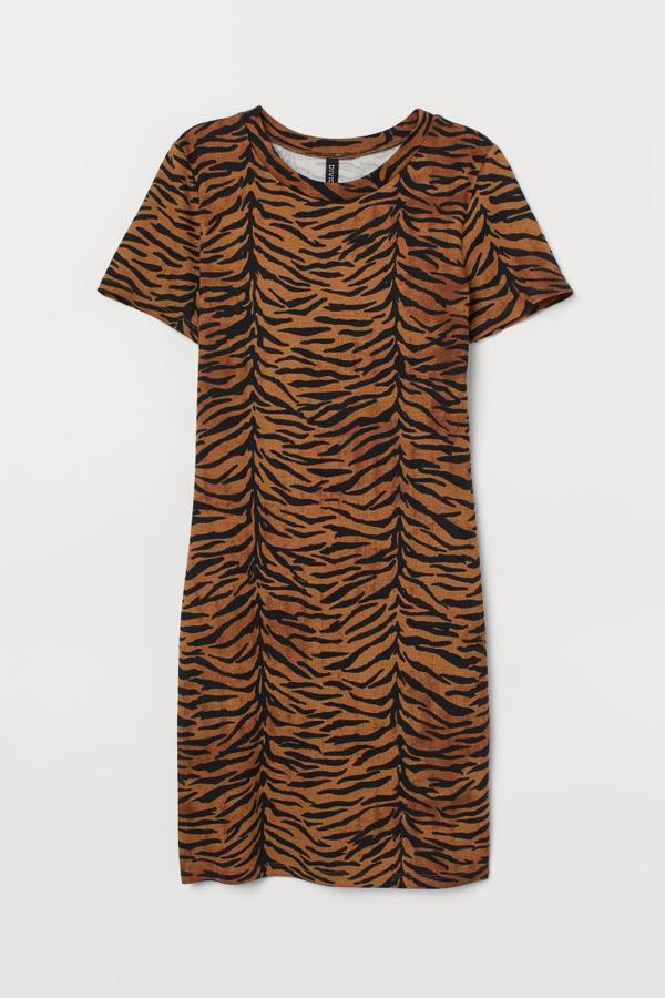 Estampado de tigre en marrón claro para este vestido de punto suave ceñido de H&M con mangas cortas y tejido elástico. Tiene un precio de 14,99 euros y está disponible entre las tallas 32 y 38.