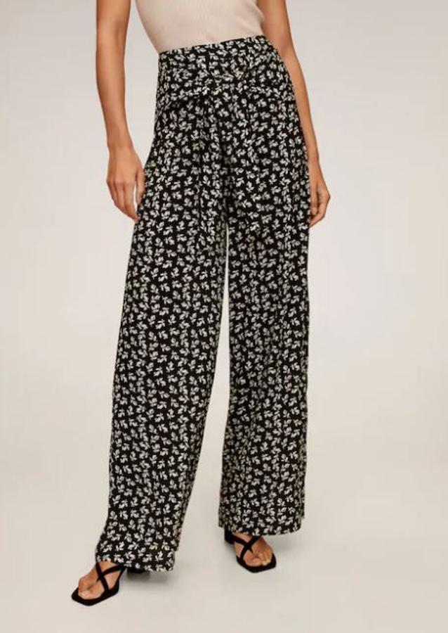 Pantalones de verano con estampado de flores y nudo delantero, de las rebajas de verano de Mango. Cuestan 19,99 eruos y valían 29,99 euros antes de las rebajas.