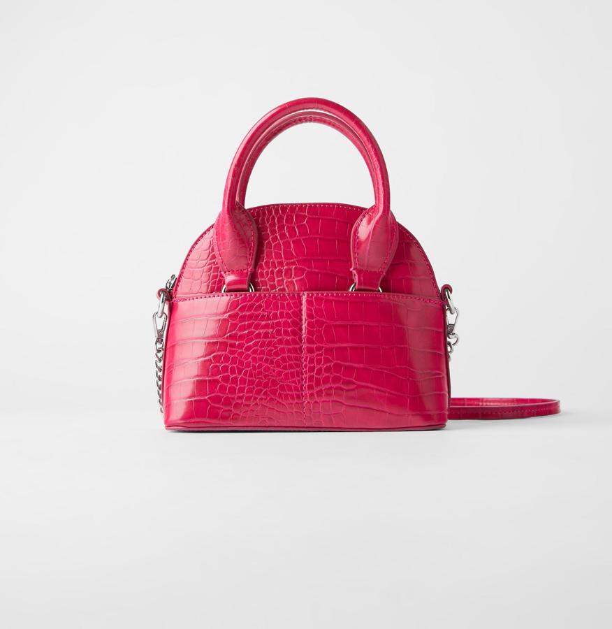 Tipo Bowling, en piel con efecto cocodrilo y dos asas cortas y una bandolera larga de cadena, de Zara (17,95 €).