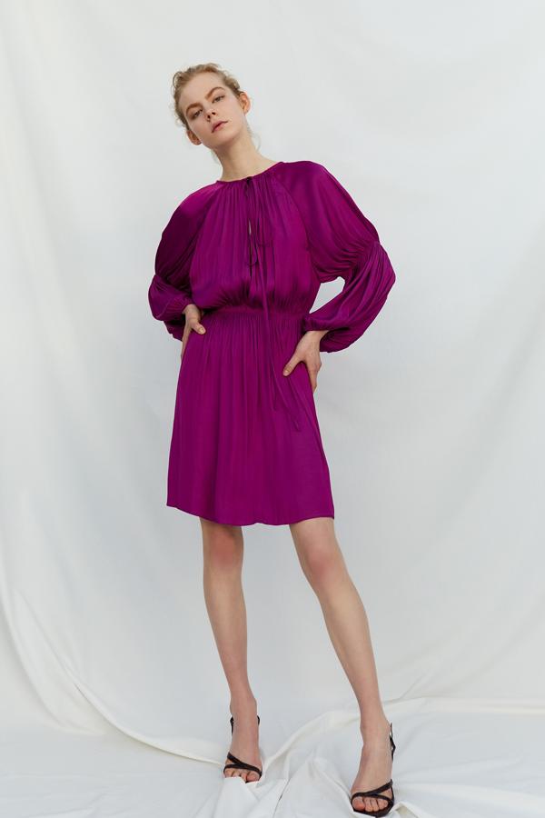 Vestido corto con fruncidos y lazada, y con las mangas adornadas con plisados (19,99 euros).