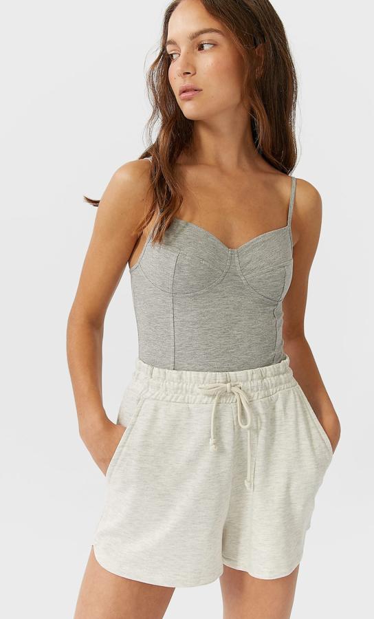 Body de escote pico y tirante fino regulable. Detalle de copas en pecho. Cierre en bajo con botones a presión (Stradivarius, 15,99 euros).