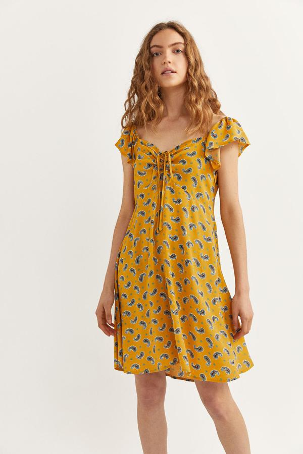 Vestido mini en color mostaza con fruncido en el escote que puedes comprar  aquí  por 14,99 euros.