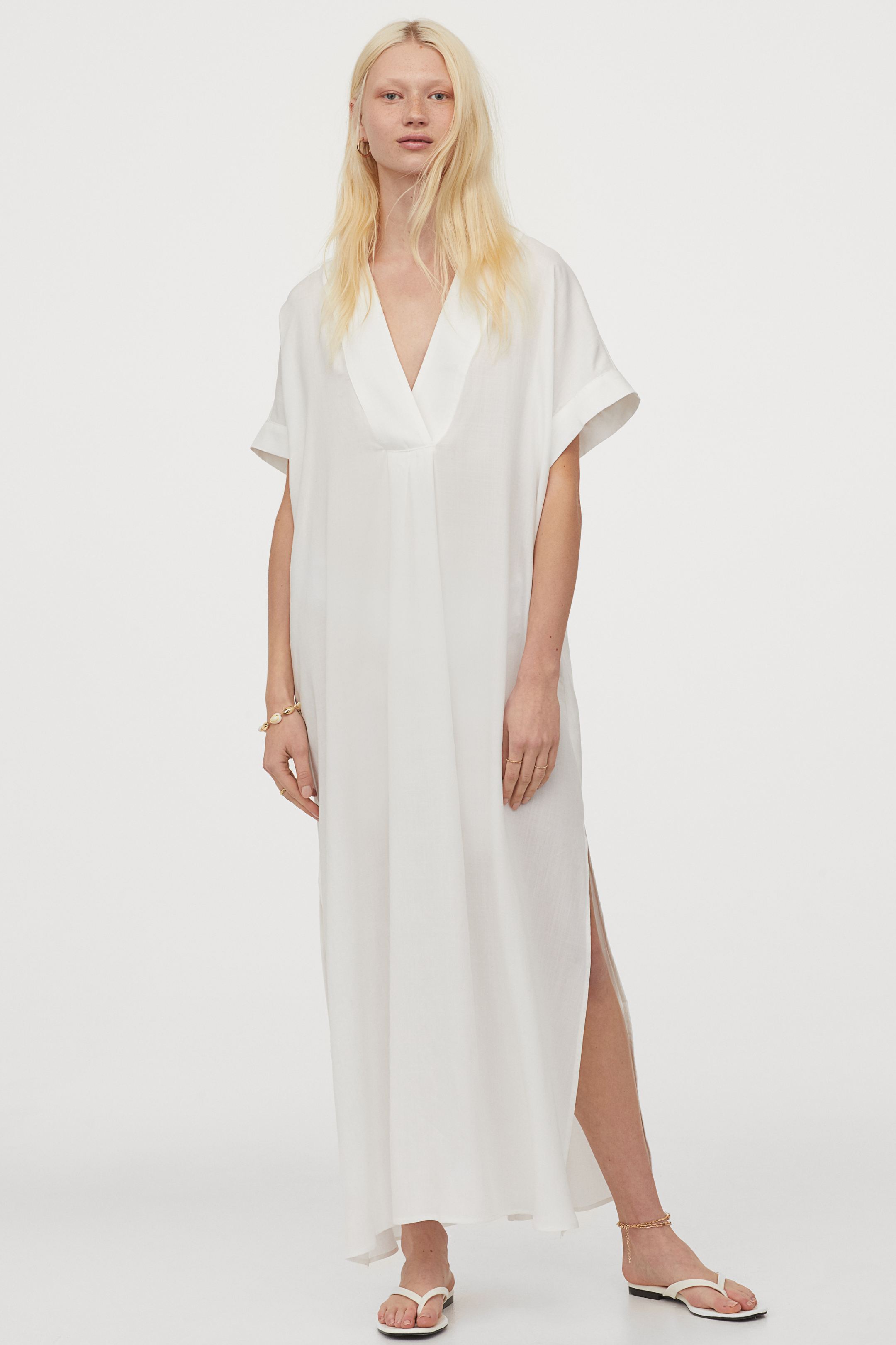 Vestido blanco tipo caftán de tejido lyocell con escote a pico y aberturas laterales. ¡Ultra cómodo, fresquito y muy favorecedor! (19,99 euros).