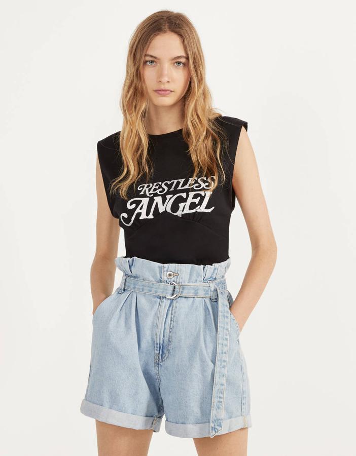 Con ligeras hombreras, sin mangas y en color negro, esta bonita camiseta de Bershka nos encanta por su tipografía y el tierno aviso que describe, “ángel sin descanso”.  Tiene un precio de 9,99 euros  y está disponible entre las tallas XS y L.