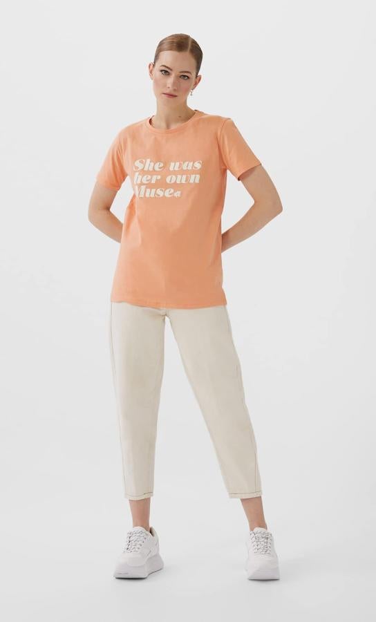 Otra de las propuestas de Stradivarius es esta bonita camiseta en color mandarina con letras en color blanco. “Ella es su propia musa” deja claras muchas ideas. Tiene un precio de 5,99 euros y está disponible entre las tallas XS y L.