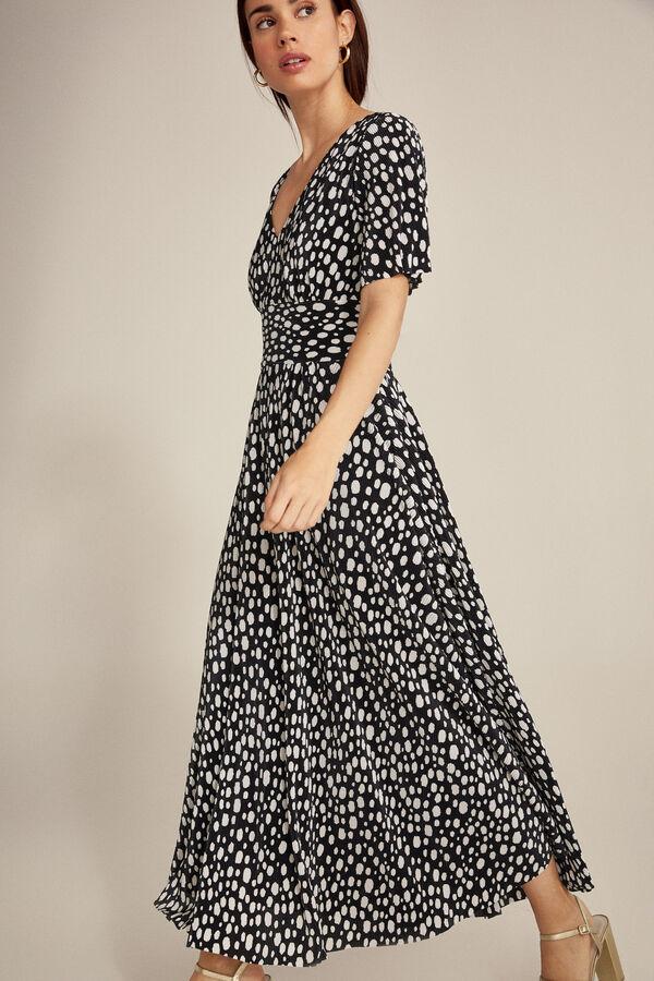 Vestido largo con falda pliasada y estampado de lunares blancos sobre fondo negro, de Pedro del Hierro disponible en Cortefiel (119 euros).