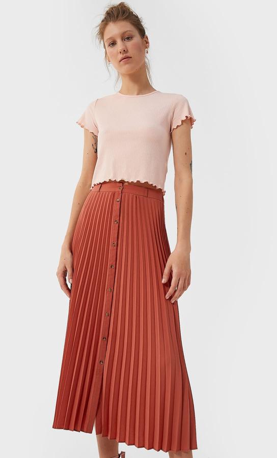 Otra prenda que nunca pasa de nada: la falda midi plisada. Nunca se tienen suficientes así que, ¿por qué no una más? Esta es en color caldero y cuesta 12,99 en las rebajas de verano de Stradivarius.