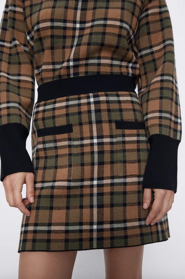 Otra propuesta en punto de Zara es esta falda mini en tonos marrones y verdes con estampado de cuadros y bolsillos delanteros de plastrón. Costaba 19,99 euros y ahora está disponible por 9,99 euros en las tallas S, M y L.