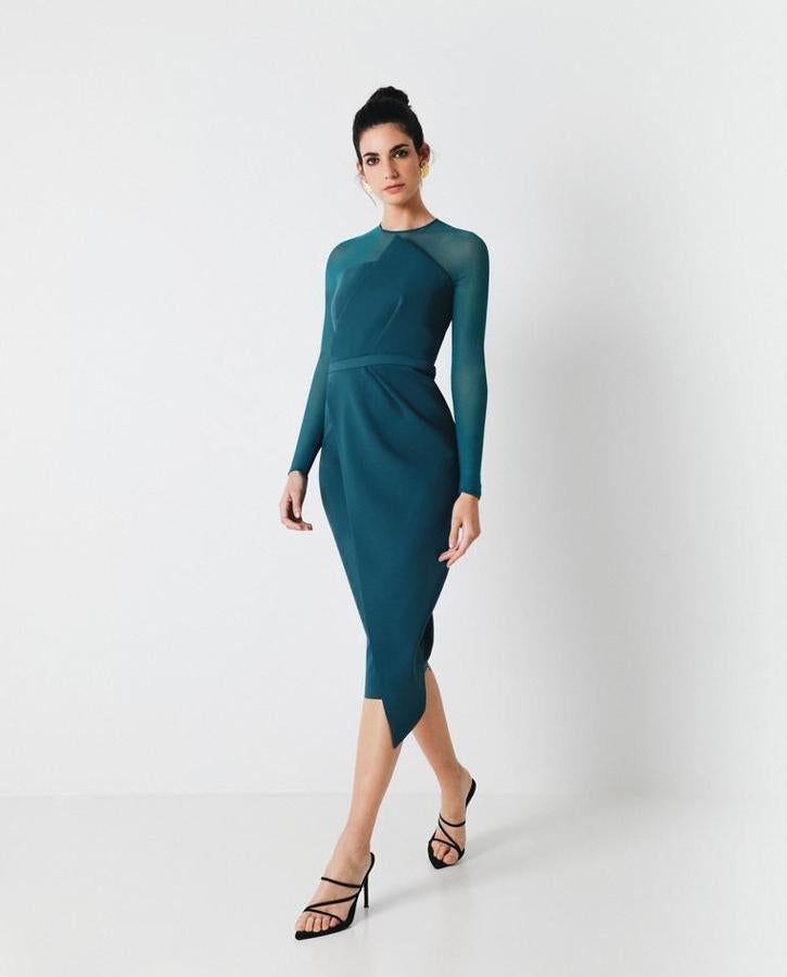 Vestido de invitada con largo mini de crepé y tul elástico verde petroleo. Su volumen en el cuerpo central y su sobrefalda envuelve el cuerpo y estiliza la figura junto con el toque del cinturón al mismo color en la cintura. La elegancia también es de colores. Costaba 295 euros y ahora te lo llevas por 236 euros.