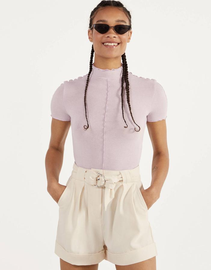 Este short en color crudo también está disponible en negro o en malva. Con cinturón del mismo tejido y vuelta en el bajo, tiene un precio de 9,99 euros.