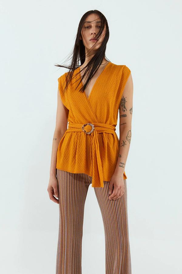 En color calabaza, este top cruzado con escote de pico y detalle de cinturón tiene un precio de 13,99 euros. También está disponible en color teja.