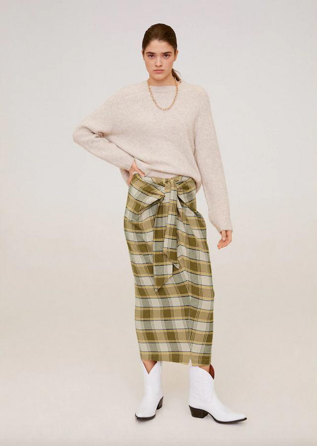 Otra de las propuestas de Mango es esta falda de cuados en tonos crudos y mostaza que solo se puede comprar en la web de la firma. Con diseño midi y corte recto, viene con nudo decorativo y de 39,99 euros ha pasado a 29,99 euros. Está disponible en las tallas S, M y L.