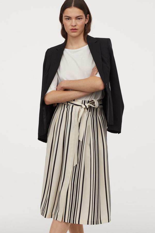 Otra de las propuestas de H&M es esta falda midi evasé con pliegues de caja delante y detrás y estampado de rayas verticales. Con cinturón extraíble a tono y bolsillos al bies, tenía un precio de 34,99 euros y ahora podemos comprarla por 15,99 euros entre las tallas 32 y 48.