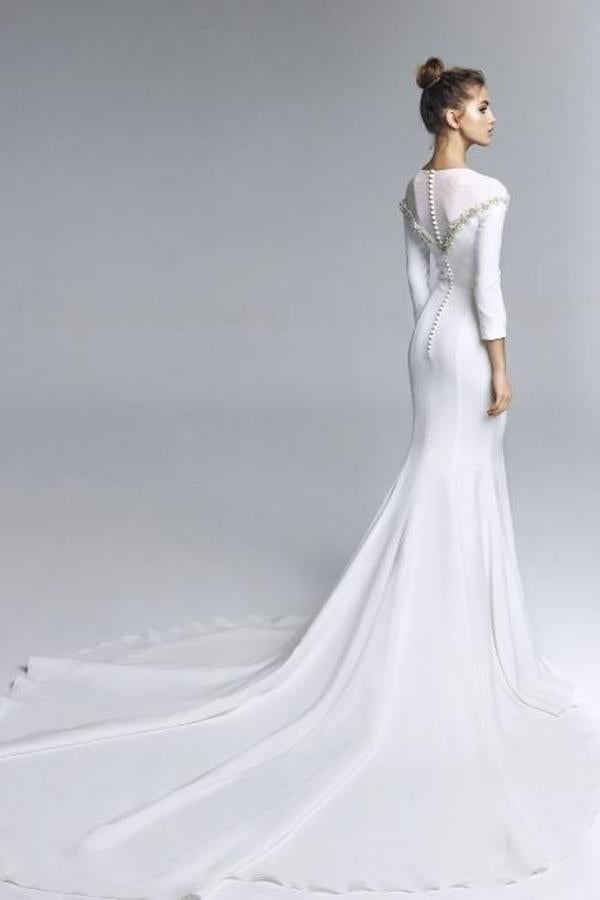 Vestido de novia realizado en crepe con tul elástico en escote y bordado en cristal a mano. Manga francesa, silueta con costadillos con amplia cola. Rebajado de 1.750 a 700 euros.