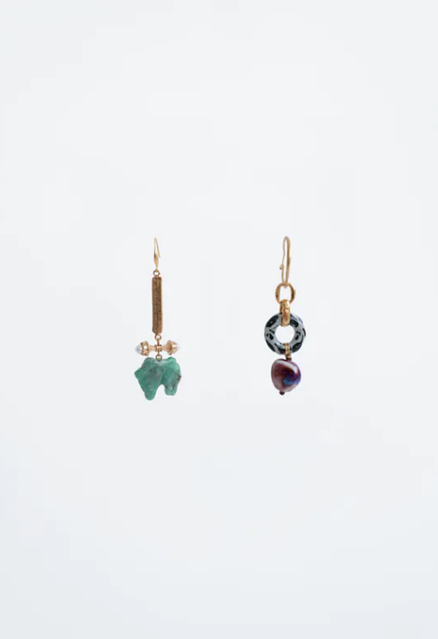 Este par de pendientes son irresistibles: porque no buscan coordinarse más que en los materiales que utilizan (resina, madera, cerámica, perla) y por su diseño horizontal, tan favorecedor. Son de Zara y cuestan 12,95 euros.