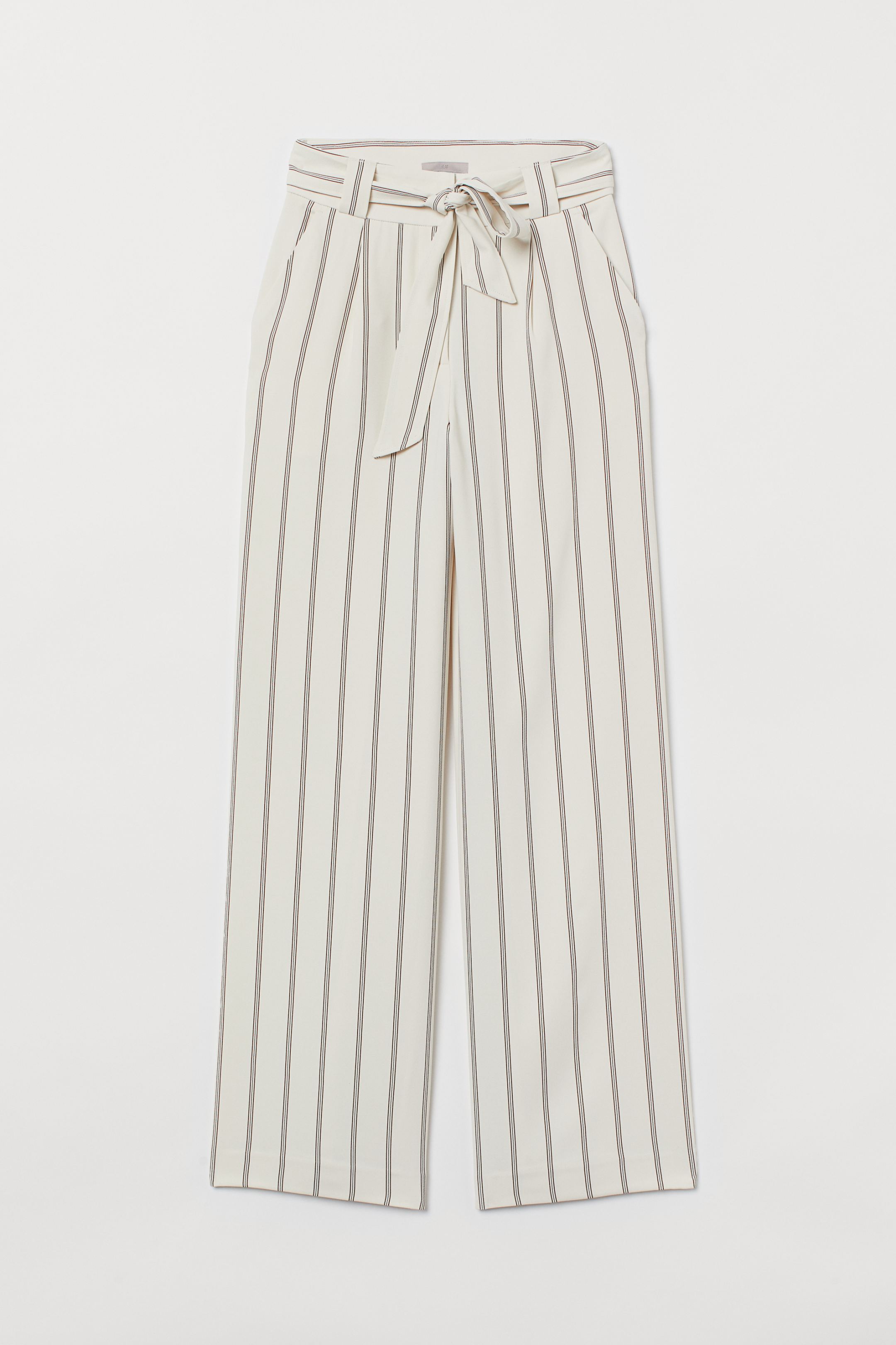 Pantalones amplios con cinturón y estampado de rayas en color blanco. Antes: 34,99 euros. Ahora: 21,99 euros.