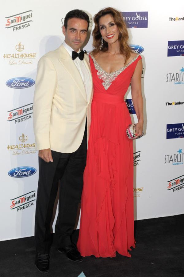 Paloma Cuevas con Enrique Ponce durante la gala de Starlite en 2014 con un vestido largo en color rojo con apliques de brillantes en el escote.