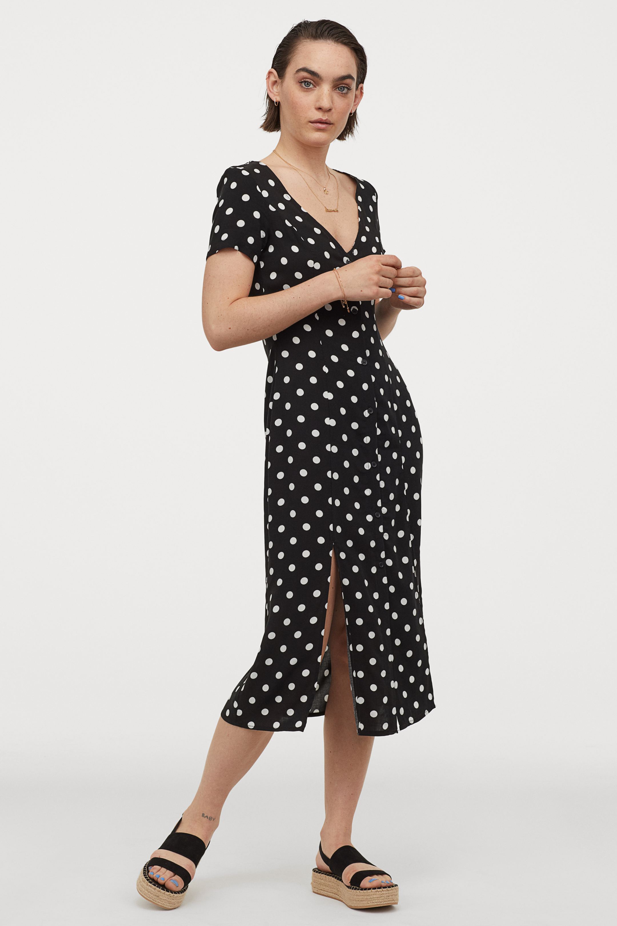 Vestido de lunares blanco y negro con escote a pico y aperturas para presumir de piernas bonitas este verano. En las rebajas de H&M por 15,99 euros.