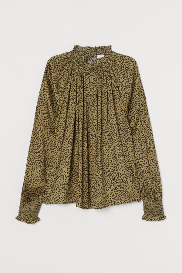 De corte amplio, con estampado de leopardo en tonos caqui y negros y mangas raglán con ribete en los puños, esta blusa de H&M con cuello elástico de volante y fruncidos decorativos tiene un precio de 19,99 euros y está disponible en las tallas 32 y 34.