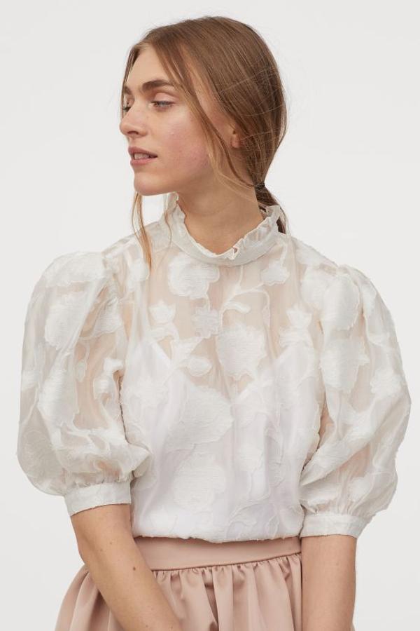 Esta blusa en organza vaporosa con diseño en tejido jacquard de H&M también viene con cuello corto ligeramente fruncido y mangas abullonadas. Está rebajada y de 34,99 euros ha pasado a costar 15,99 euros. Solo queda en la talla 32 y se está agotando.