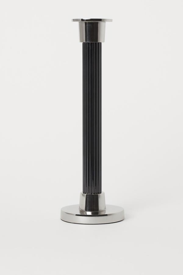 Este portavelas de metal en color negro cuenta con diámetro inferior a 8 centímetros y una altura de 25,5. Tiene un precio de 16,99 euros.