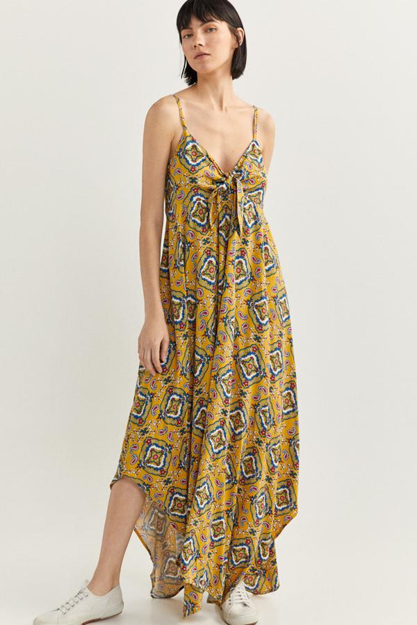 Este vestido maxi es de lo más favorecedor. En color amarillo con estampado de otros colores, cuenta con detalle de nudo en la espalda y bajo asimétrico. Es de Springfield y tiene un precio rebajado de 24,99 euros.