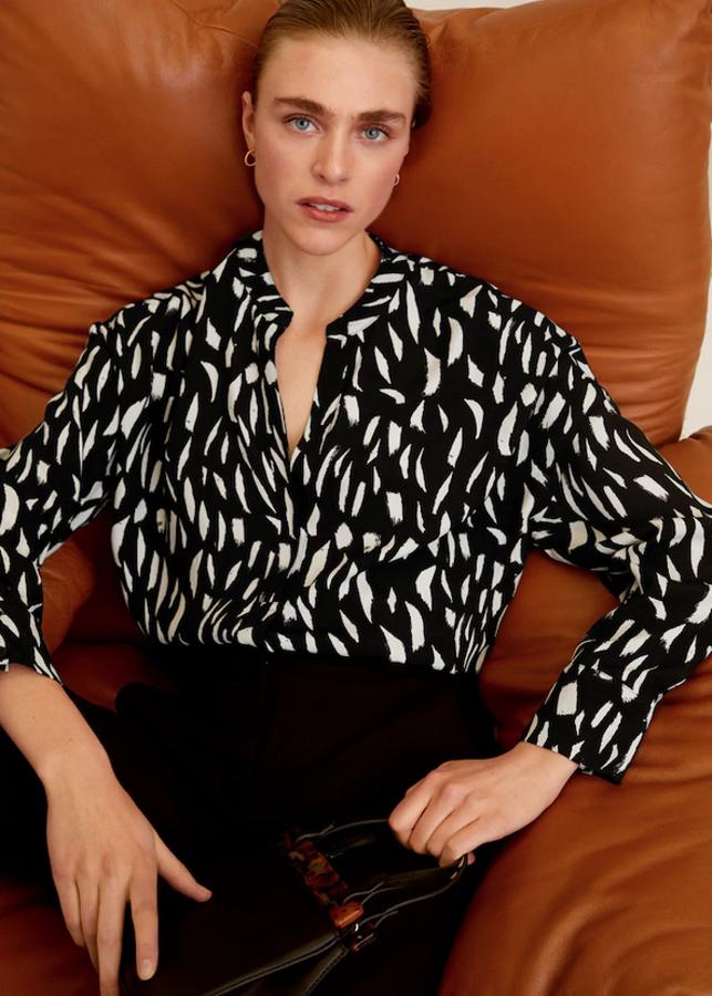 Escote de pico y mangas largas para esta blusa fluida con cierre de botones y estampado en blanco sobre fondo negro para esta blusa que costaba 25,99 euros y ahora podemos comprar por 9,99 euros en las tallas XS y M.