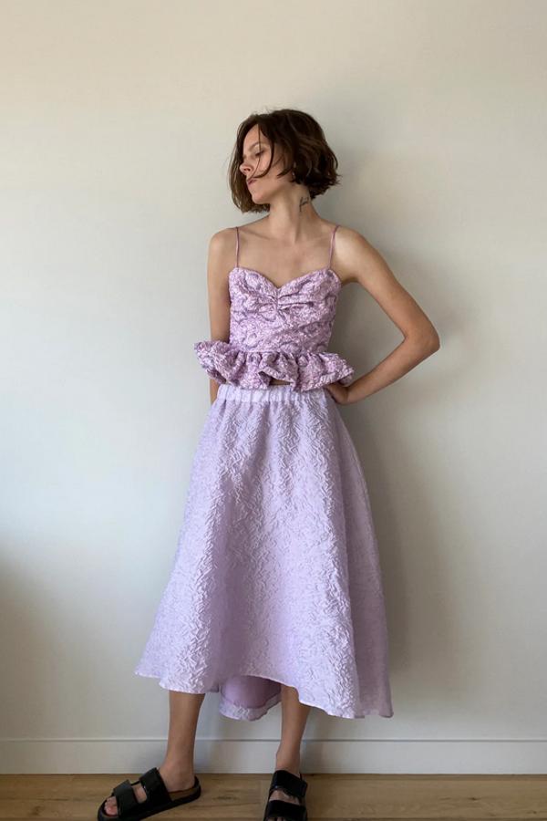 El lila no podía faltar en esta selección y lo pone esta bonita falda midi de organza con diseño arrugado, bajo asimétrico y forro interior. Pertenece a la colección edición limitada y tiene un precio de 39,95 euros. Está disponible entre las tallas XS y XL.