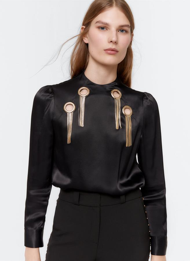 Blusa de seda negra con arandelas en el pecho y colgantes de cadenas, de las rebajas de Uterqüe (39,95 €).