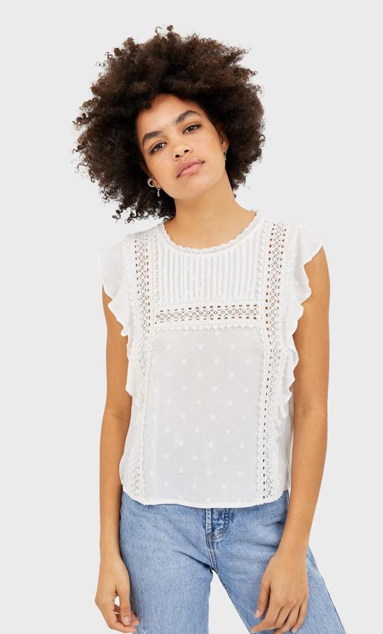 Con manga sisa, volantes laterales, plumetti y bordado crochet, esta blusa blanca llega cargada de tendencias. De 17,99 euros ha pasado a 7,99 euros y todavía está disponible en las tallas S y M.