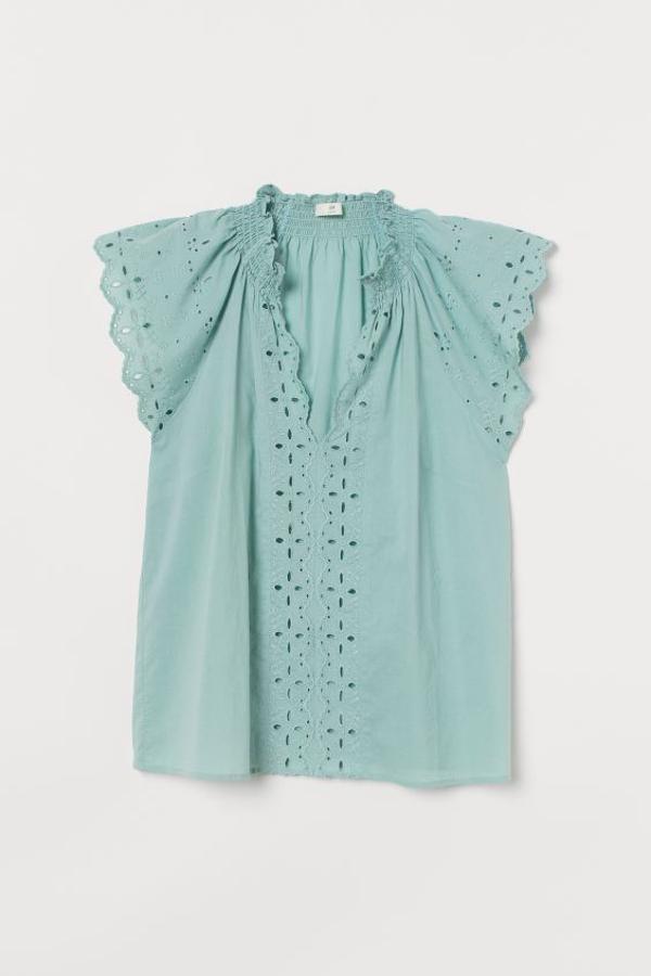 En color verde palo, confeccionada en algodón vaporoso y con escote de pico festoneado, esta blusa con cuello elevado fruncido, mangas japonesas y bordado ingles ene l frontal cuesta 24,99 euros. Solo queda en la talla 34.
