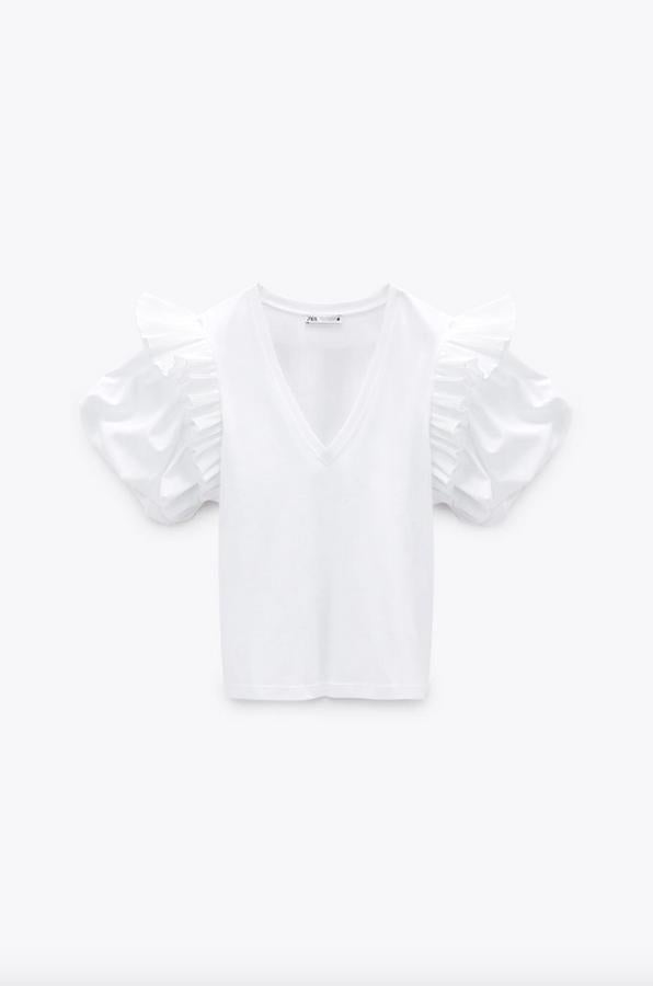 Los volantes también han llegado a las camisetas y esta en color blanco con escote de pico es una buena prueba. Situados sobre la manga corta abullonada, está confeccionada en algodón orgánico y cuesta 17,95 euros. Podemos encontrarla entre las tallas S y XL.