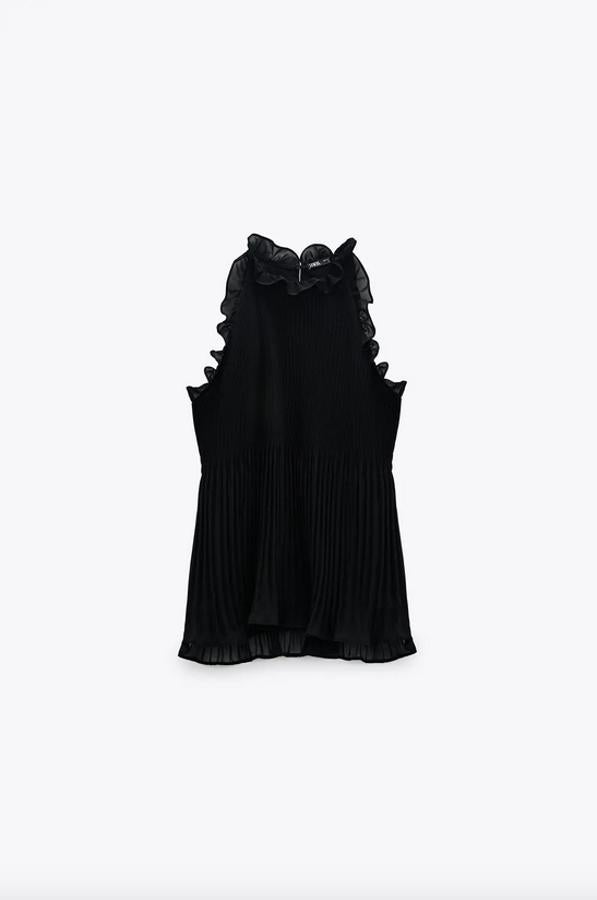 Otra propuesta en color negro es este top de cuello halter con volantes cortos, que también están presentes en la manga sisa. De diseño plisado y con forro interior, tiene un precio de 22,95 euros y está disponible entre las tallas XS y XL.