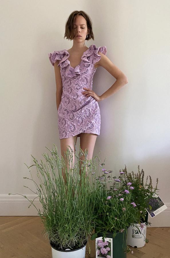 Aunque lo habitual en los vestidos son los volantes en el bajo, este en color lila los tiene en las mangas cortas y el escote de pico. Con detalle de relieves combinados a contraste y bajo asimétrico con frunces, tiene un precio de 49,95 euros y está disponible entre las tallas XS y L.