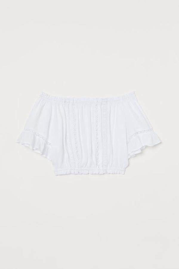 Esta blusa corta de H&M está confeccionada en tejido arrugado de viscosa y viene con ribetes de encaje, elástico en la parte superior y en el bajo y mangas cortas con ribete de volante. De 17,99 euros ha pasado a 12,99 euros y está disponible únicamente en la talla 44.