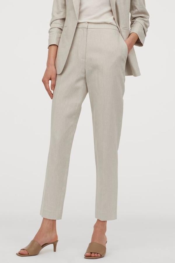 En H&M hemos encontrado este pantalón pitillo de tela en color beige con bolsillos al bies y perneras tobilleras con raya. De 29,99 euros han pasado a 17,99 euros y están disponibles en las tallas 32, 36 y 42, y entre la 46 y la 50.