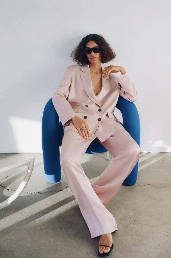 Una blazer de cuello y solapa, con mangas largas y bolsillos delanteros con solapa y un pantalón de perneras anchas y cintura elástica en la espalda componen este traje en rosa claro. La blazer cuesta 49,95 euros, el pantalón 29,95 euros.