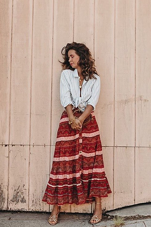 Sara Escudero actualiza un look con falda midi con el sencillo gesto de anudar la camisa.