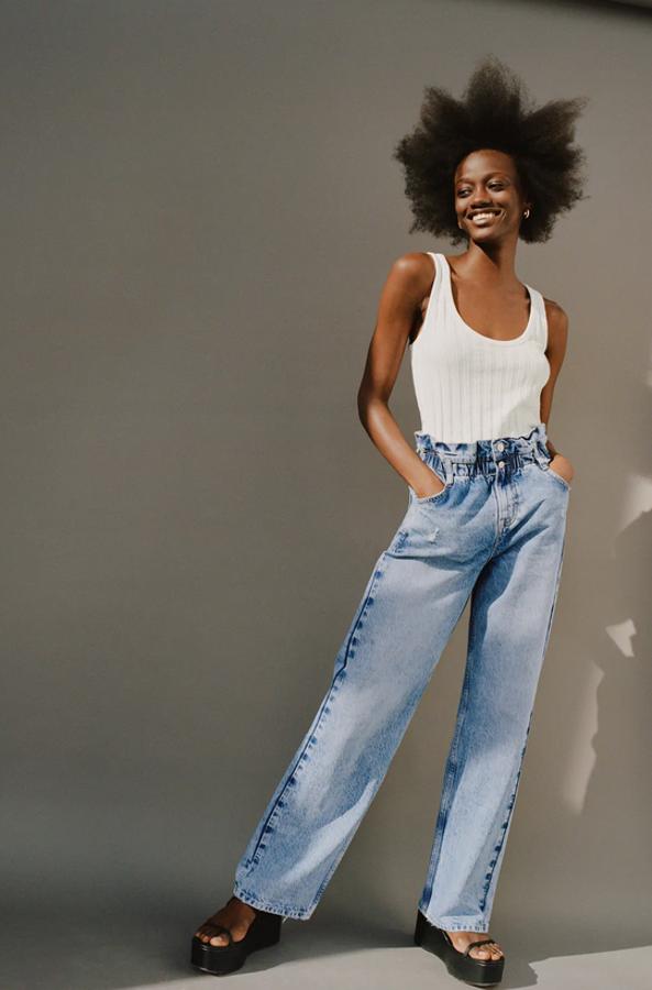 Con tiro alto y cintura elástica, estos vaqueros de Zara en azul medio con efecto lavado tienen pernera ancha y cierre frontal con dos botones metálicos. Cuesta 29,95 euros y está disponible entre las tallas 32 y 42.