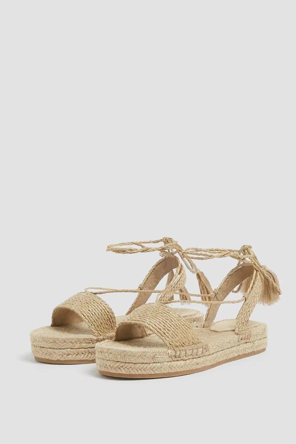En color natural, esta alpargata de yute cuenta con cierre mediante atado alrededor del tobillo con cuerda y tiene un precio de 29,99 euros.
