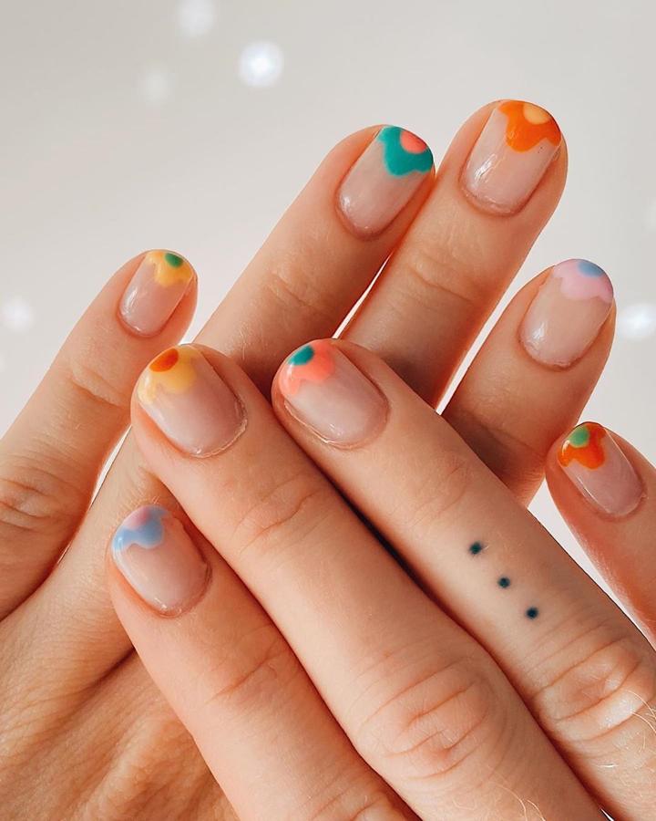 Otra de las versiones de las versiones de la manicura francesa es esta. Un diseño con flores en tonos vivos perfectos para el verano y con los que llevar un diseño sutil si no eres demasiado atrevida.