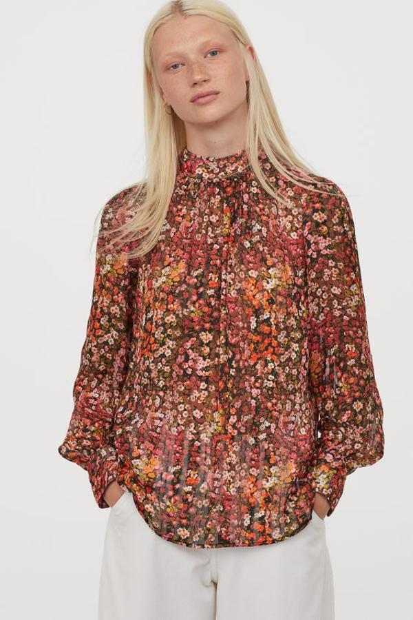De venta exclusiva en la web de H&M hemos encontrado esta blusa holgada vaporosa confeccionada en tejido arrugado de poliéster reciclado con cuello elevado y mangas largas abullonadas con botones revestidos. Cuesta 14,99 euros y está disponible entre las tallas XS y XXL.