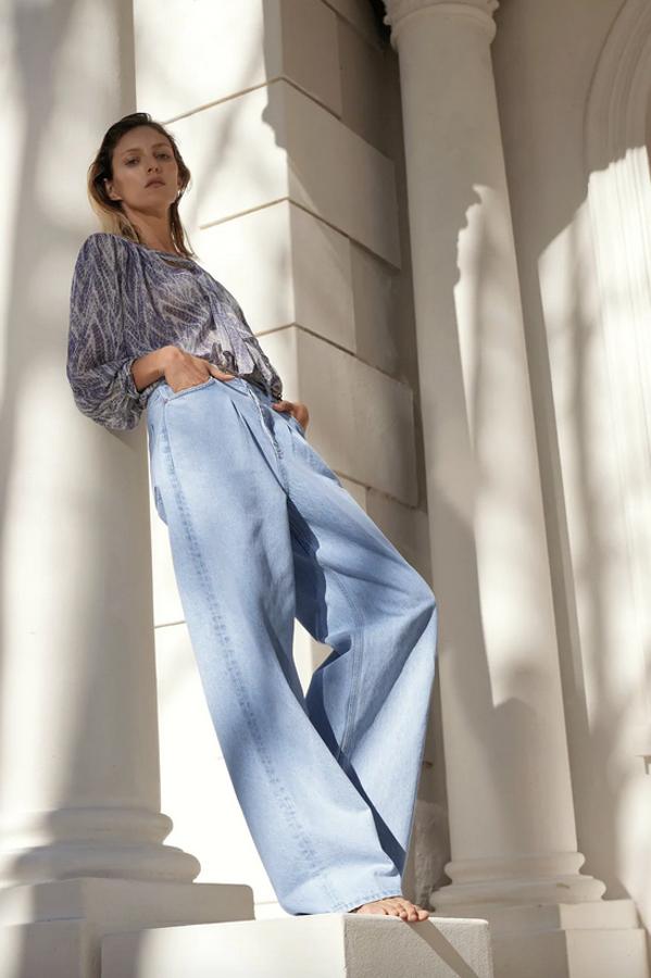 Con estampado de serpiente en tonos azules y grises, esta blusa de cuello redondo con lazo viene con escote de pico y manga larga viene con botones forrados a tono. Tiene un precio de 19,95 euros y podemos encontrarla entre las tallas XS y XL.