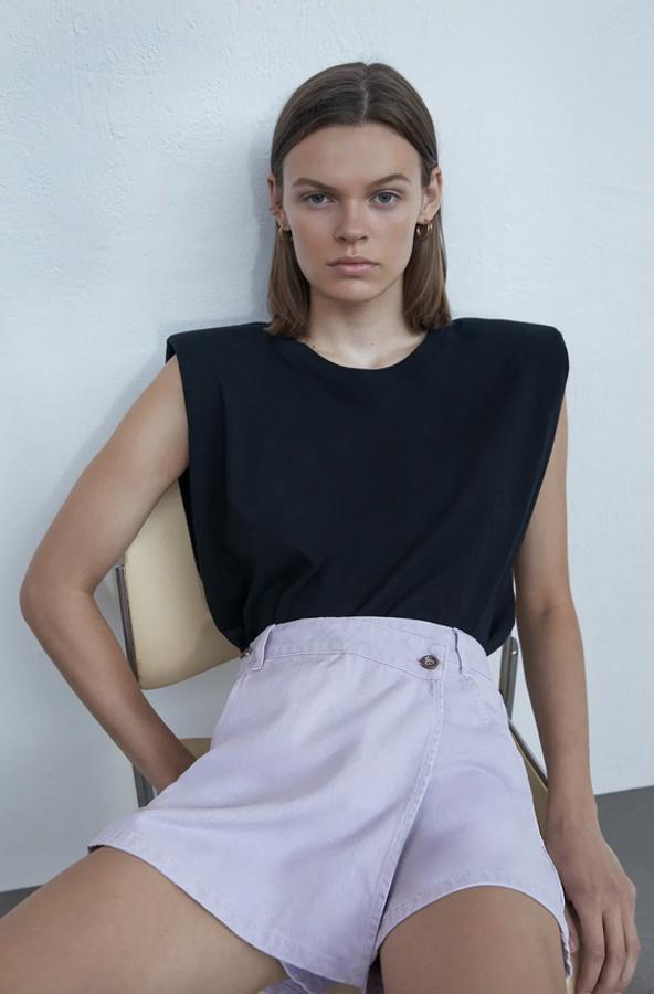 Confeccionada en denim de color lila, esta bermuda con delantero tipo pareo asimétrico es de Zara y viene con bolsillos laterales y detalle de rotos. Cuesta 19,95 euros y está disponible entre las tallas XS y XL.