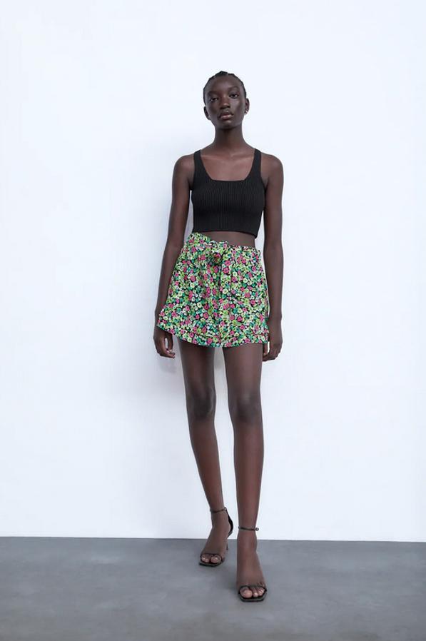 De tiro alto, con cintura elástica en la espalda y detalle de lazo combinado a tono, esta falda bermuda de Zara con bajo acabado en volantes cuesta 22,95 euros y está disponible entre las tallas XS y XL.