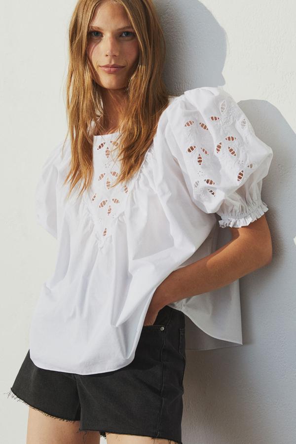 Esta blusa en popelina de algodón con inserciones caladas cuenta con manga globo con remate de elástico y tiene un precio de 24,99 euros.