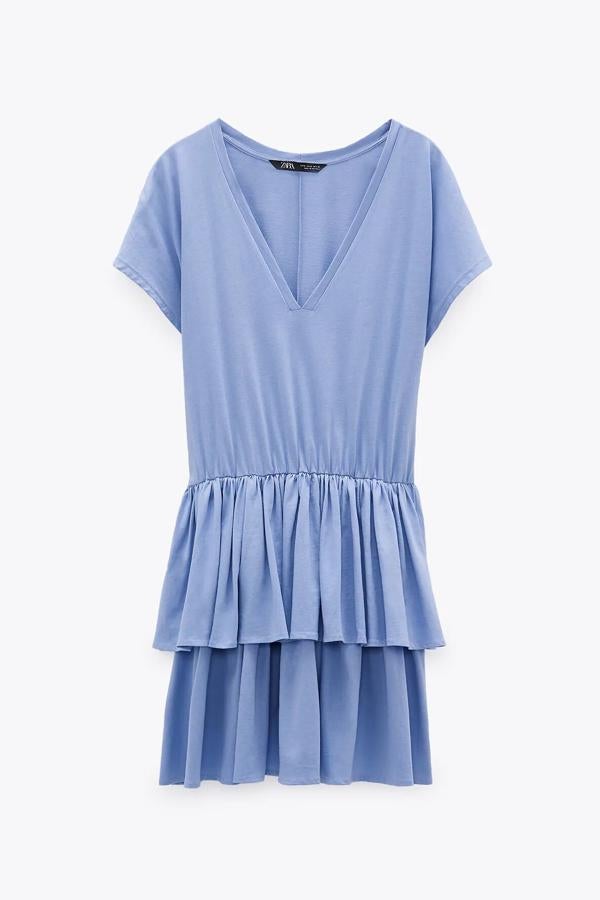 En color azul claro, este vestido corto de escote de pico y bajo acabado en volantes cuenta con detalle de elástico en la cintura y tiene un precio de 19,95 euros.