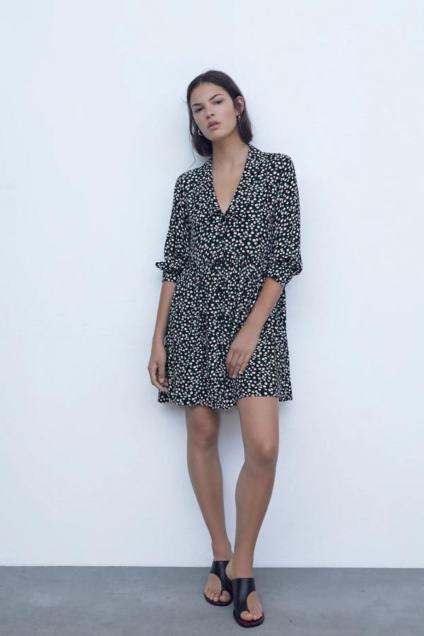 En color negro con estampado de flores, este vestido mini de escote de pico con solapa y manga larga cuenta con cierre frontal con botones y tiene un precio de 29,95 euros.